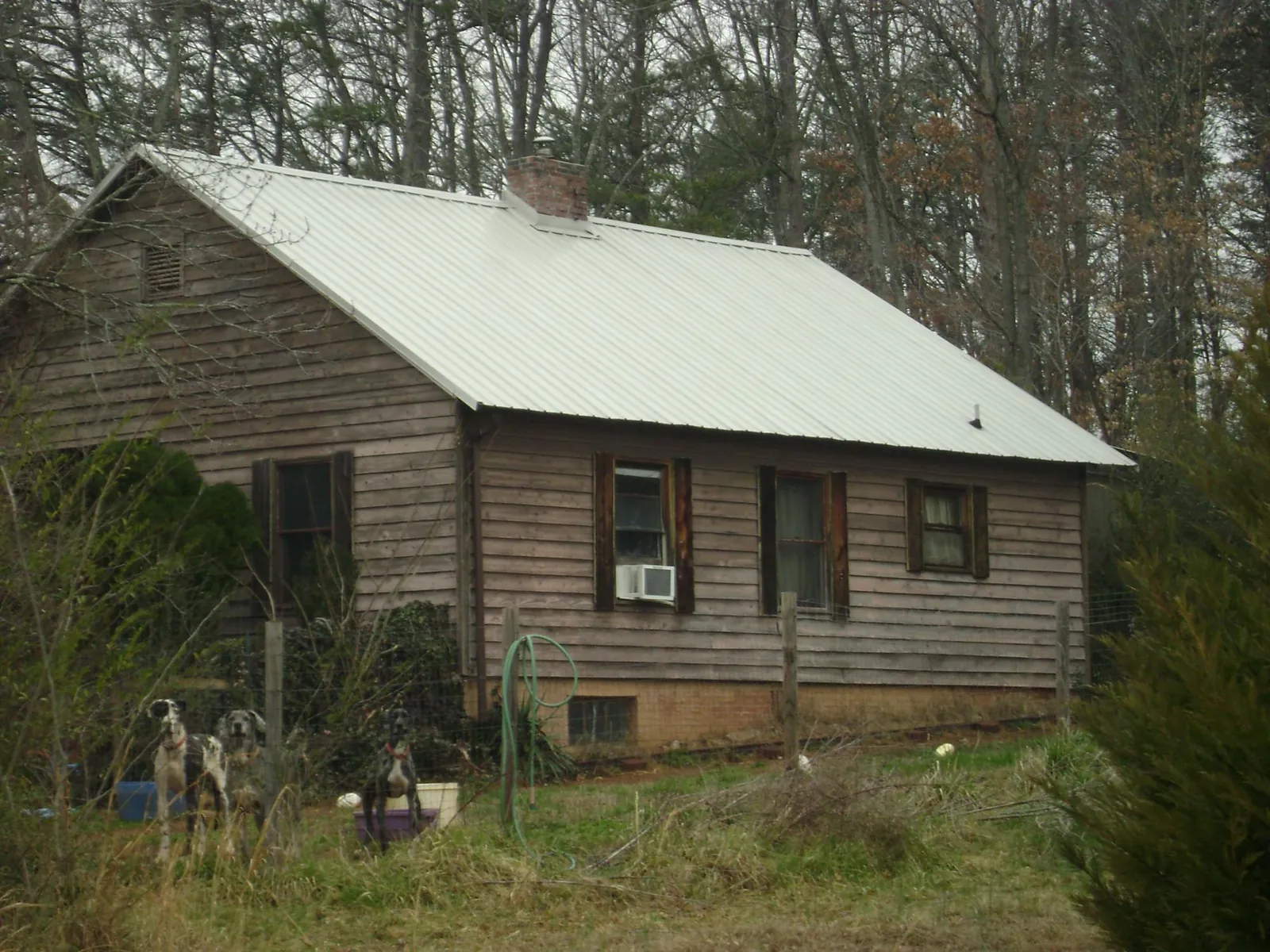 White metal roof on an old wood sided farmhouse, from a Metal Roof Installation job in Fontana